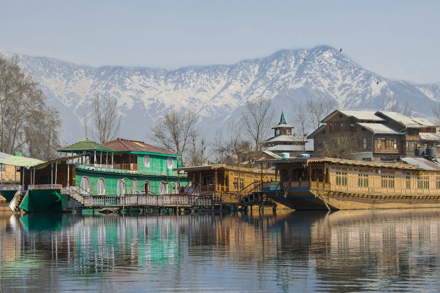 Houseboats on Dal Lake with snow-capped mountains behind