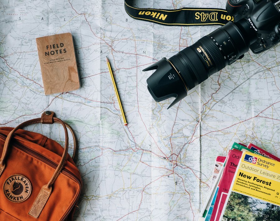 Map, camera and travel notebook laid out for trip planning