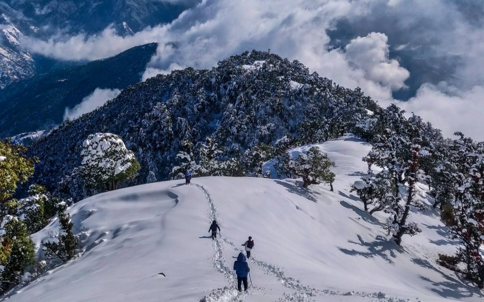 Trekkers on a snowy ridge in Uttarakhand
